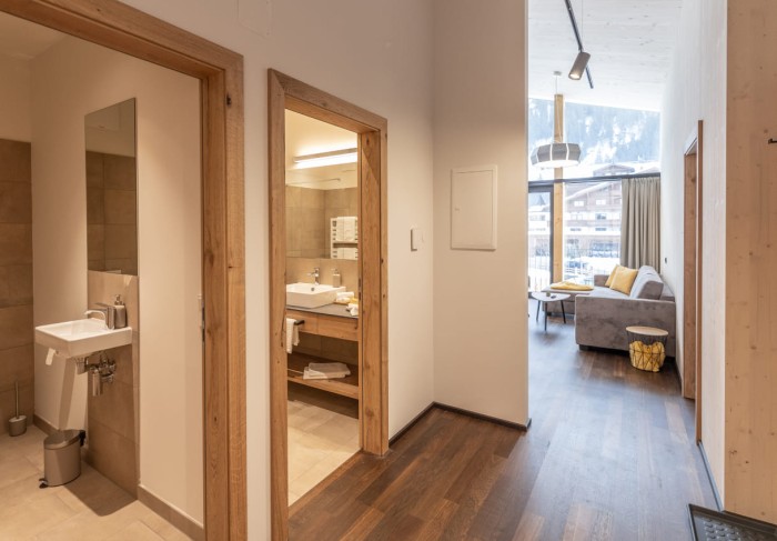 Flur mit Blick ins WC, Bad und Wohnzimmer mit Balkon