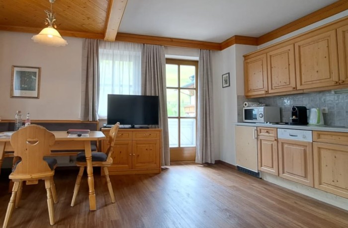 Wohnbereich mit TV und Küche / Ausgang Balkon